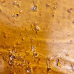 Slurricane Shatter – Premium cannabis concentrate with a golden, glass-like texture, offering potent effects and a rich berry and tropical flavor.