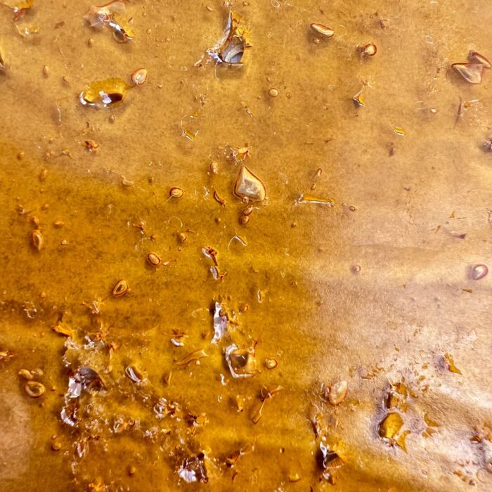 Slurricane Shatter – Premium cannabis concentrate with a golden, glass-like texture, offering potent effects and a rich berry and tropical flavor.