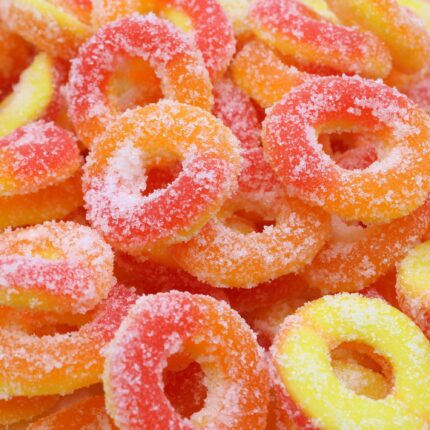 Fuzzy Peach Rings 240 MG – THC-infused peach gummies with bright orange colour, sugar coating, and balanced relaxing effects.
